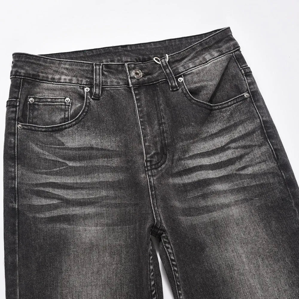 Men's black washed denim jeans on a flat surface showing full leg and pocket details