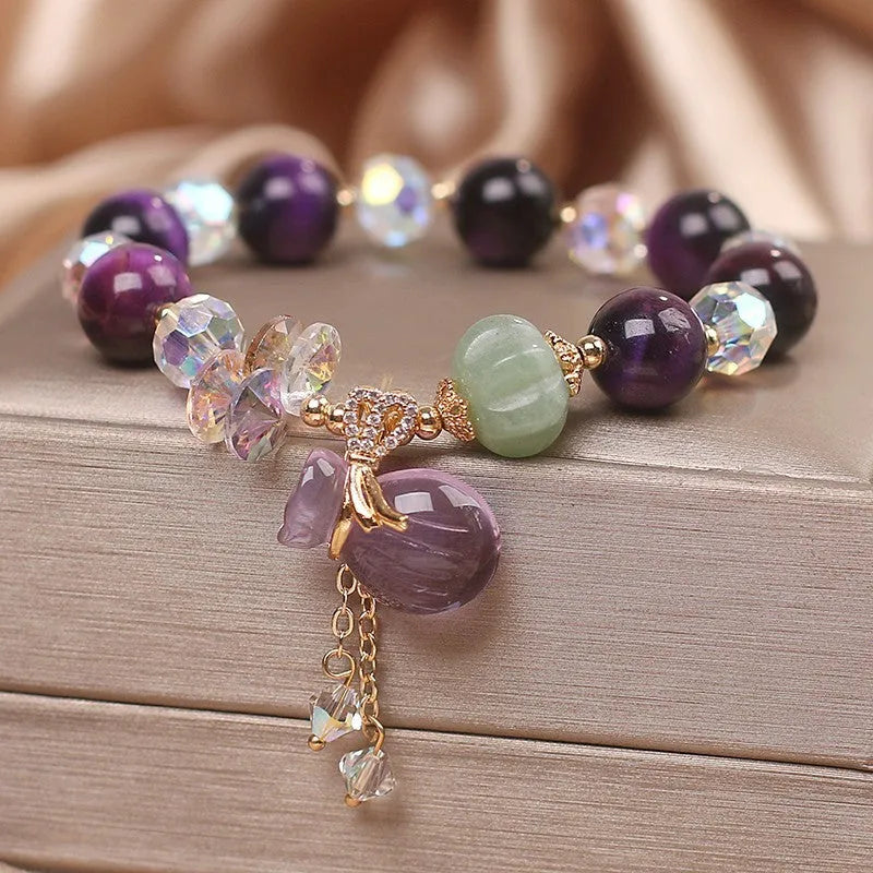 Women's forest style bracelet with purple tiger eye money bag pendant and rhinestone crystal details