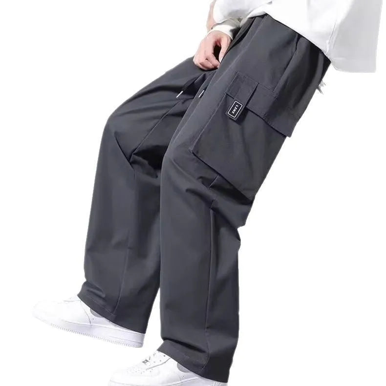 Boy wearing army green straight-leg cargo pants with large side pockets and a drawstring waist.