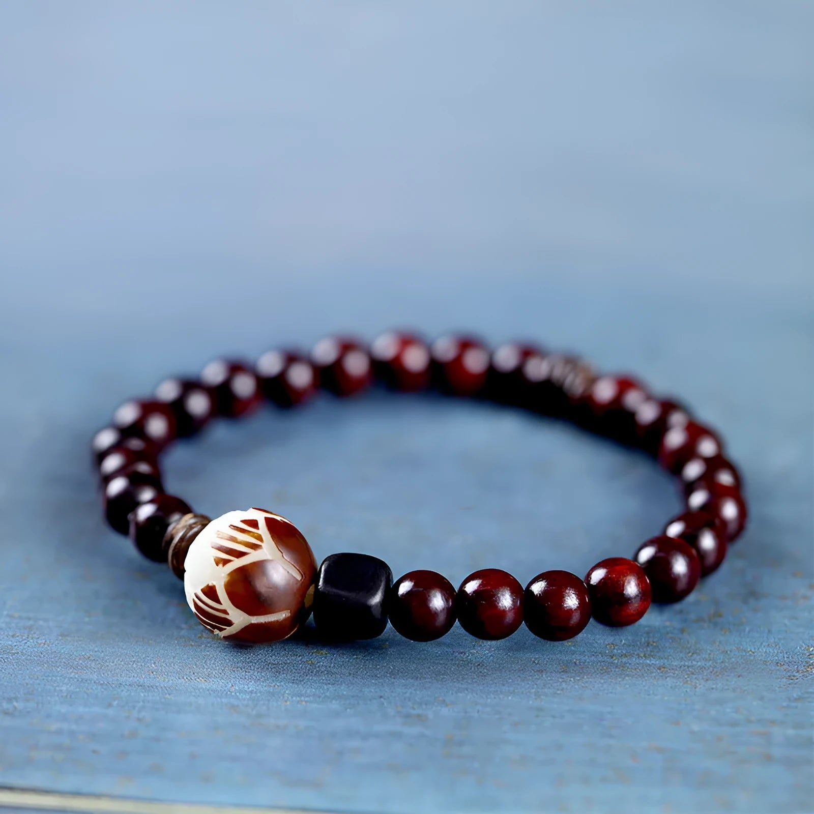 Rosewood bracelet with knitted construction showing floral carving details and 10mm diameter