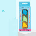 Children's writing orthosis set with five coloured pencil grips and a corrector tool on a table.