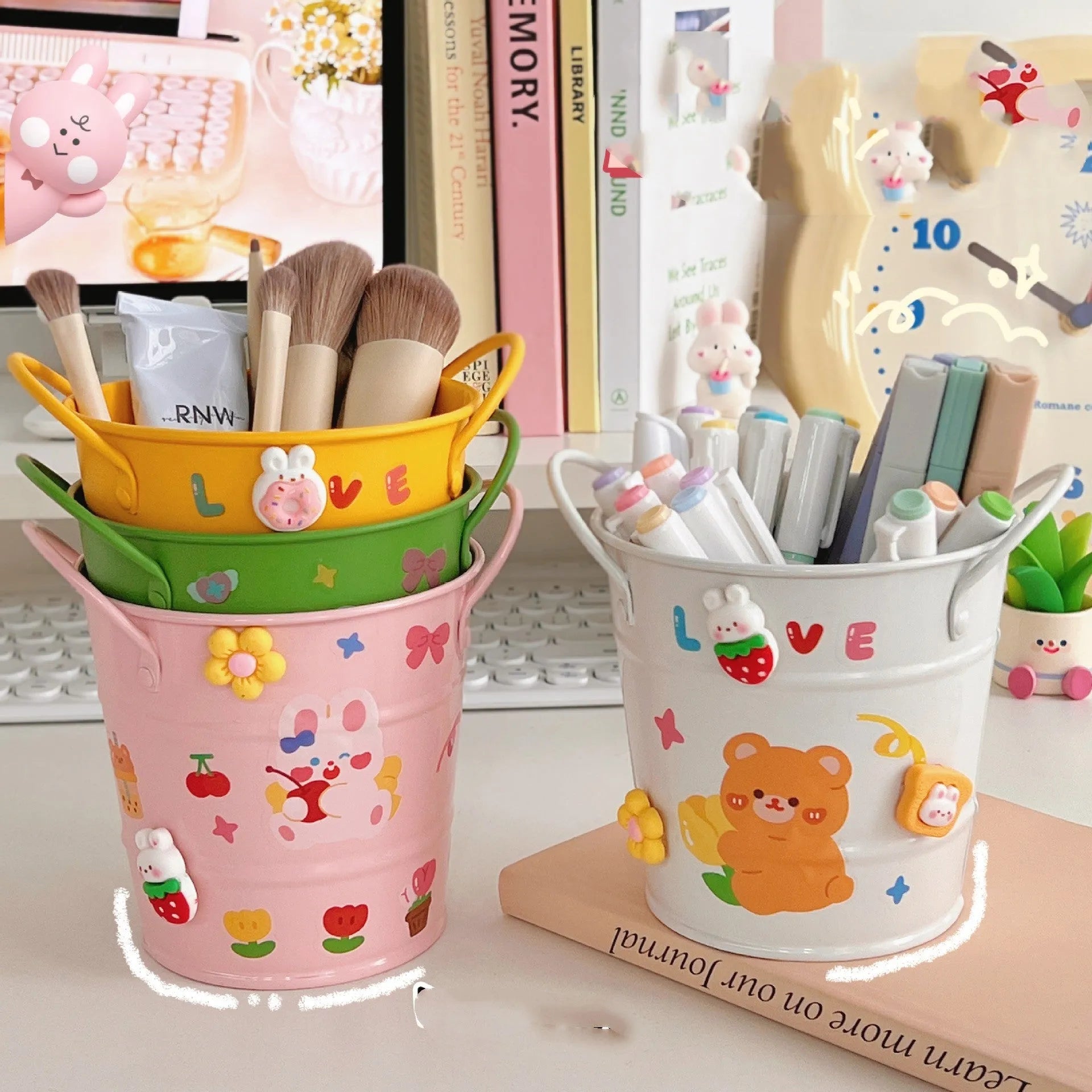 Round metal pen holder in a choice of colours, some with decorative sticker patches, on a wooden desk.