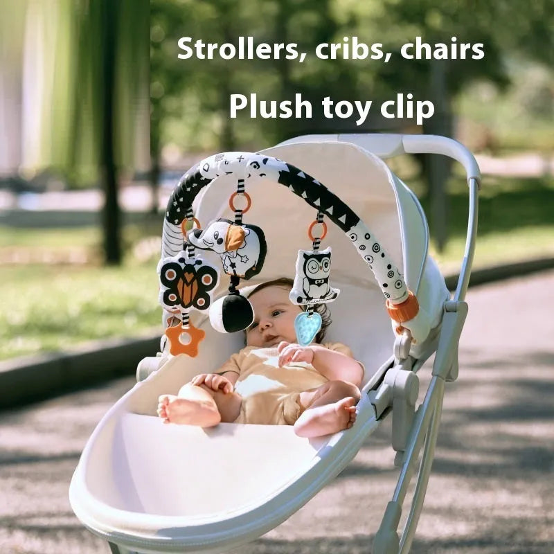 Baby lathe clip hanging plush toy in black and white, with pull vibration teether and BB call, attached to a cot side