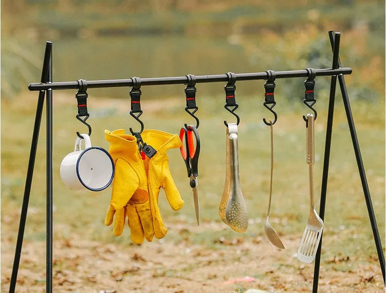 Aluminium alloy portable folding clothes drying rack with triangular frame and top tray, set up outdoors.