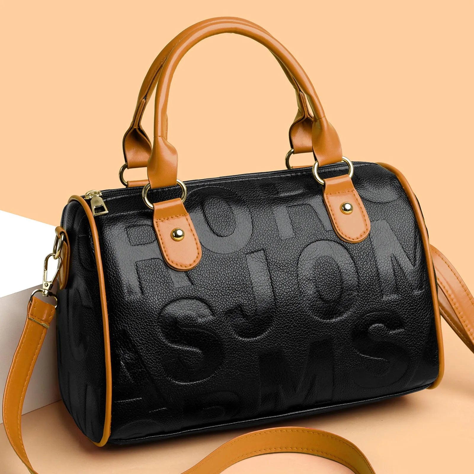 Brown cylindrical crossbody bag with three shoulder straps showing textured PU material