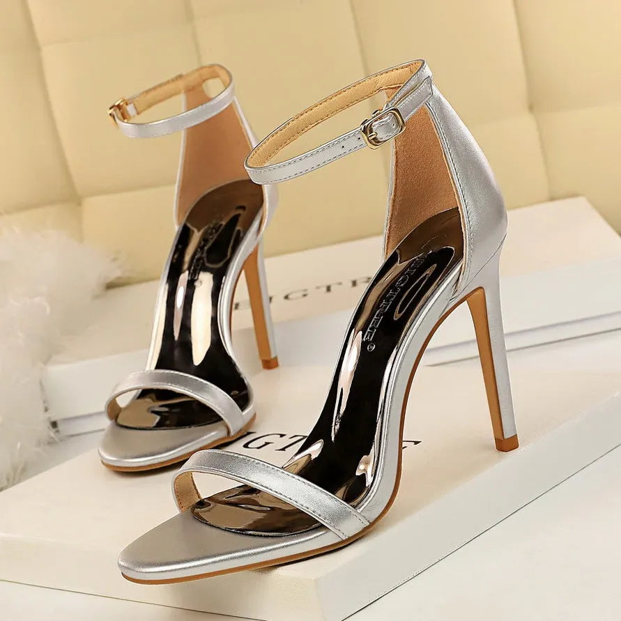 Women's open toe ankle-strap high heels with a buckle fastening, shown in one of six available colours.