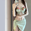 Green women's bikini three-piece set with triangle top, briefs, and skirt cover-up