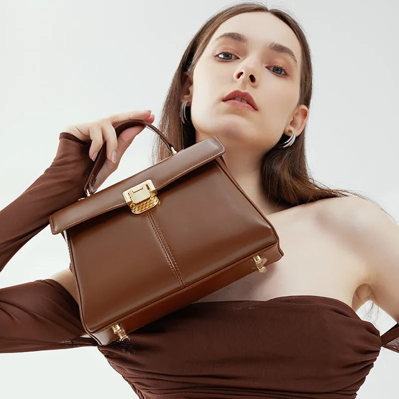 Black genuine leather women's shoulder bag with a clasp closure and long adjustable strap.