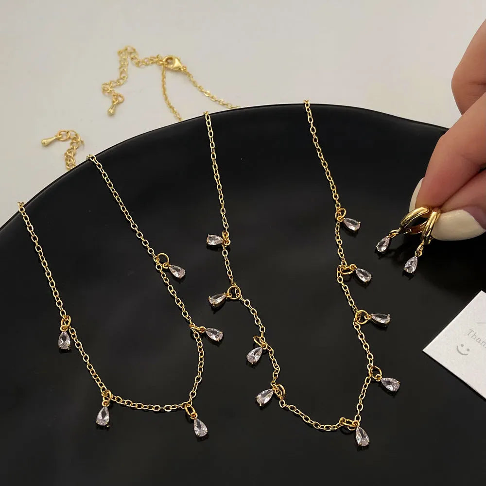 Zircon jewellery set with geometric necklace, matching earrings, and anklet.