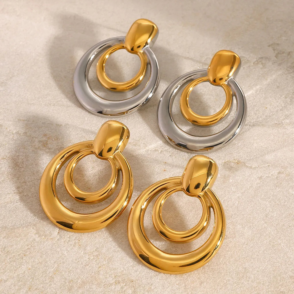 A pair of round, geometric double-layer hollow stud earrings with an 18K gold plated finish.