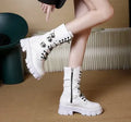 Black women's mid-calf boots with metal buckles and a side zip on a white background.