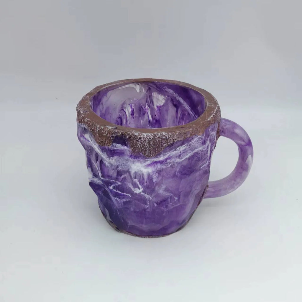 A purple resin coffee mug with a handle, showing a crystal-like structure, on a table.