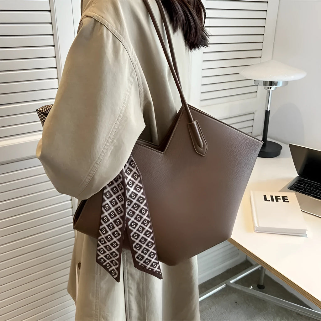 Large beige PU leather women's shoulder bag with adjustable straps on a white background.