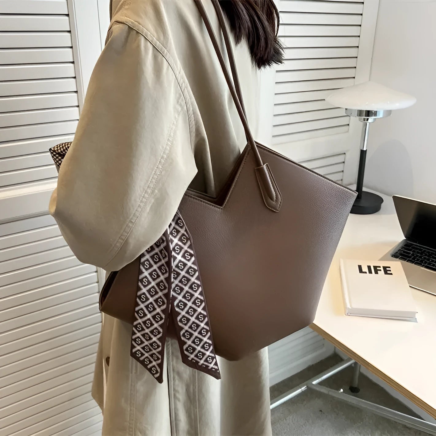 Large beige PU leather women's shoulder bag with adjustable straps on a white background.