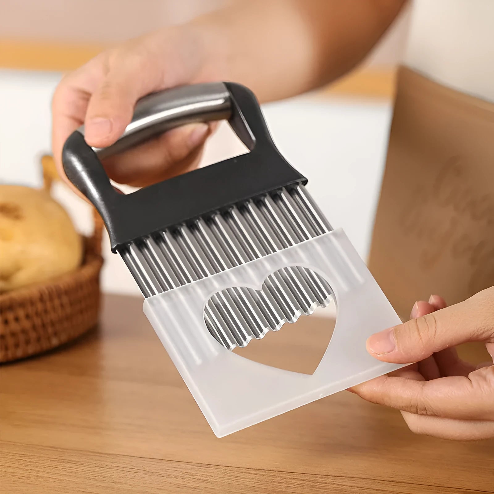 Stainless steel potato wave knife for making crinkle-cut chips on a wooden kitchen surface.