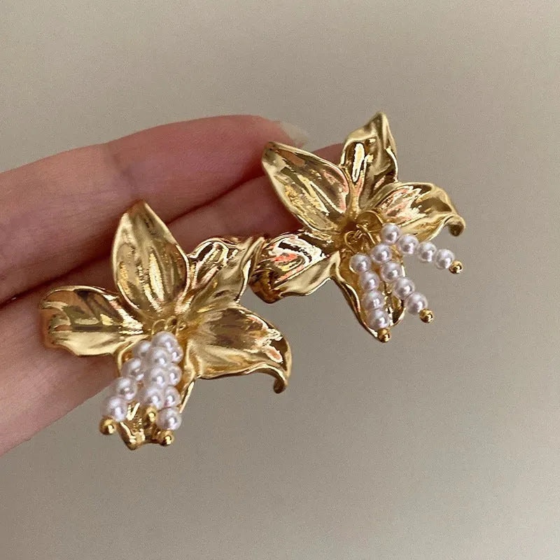Golden metal flower earrings with exaggerated design and personalised pearl elements