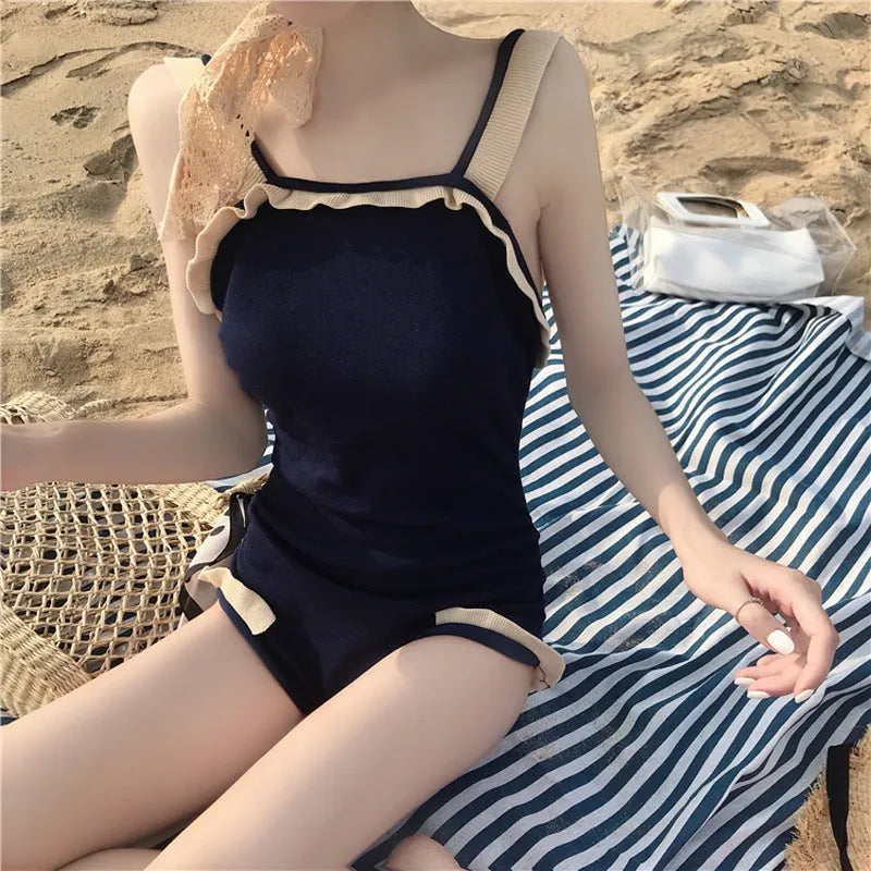 Women's conservative one-piece swimsuit in nylon fabric showing colour options including black with white edge