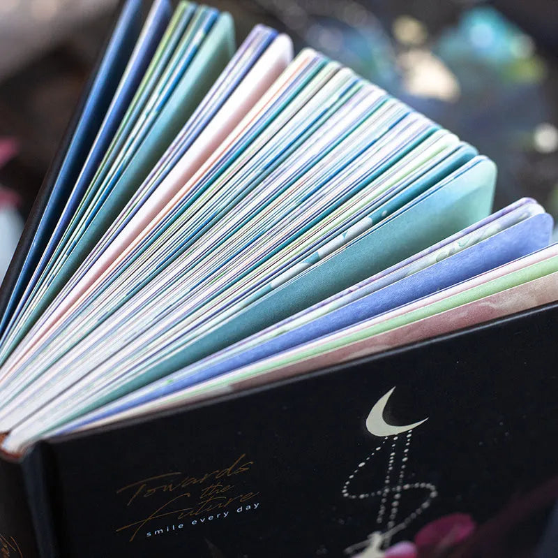 A5 hardback notebook with luminous cover open to show colour illustrated pages.