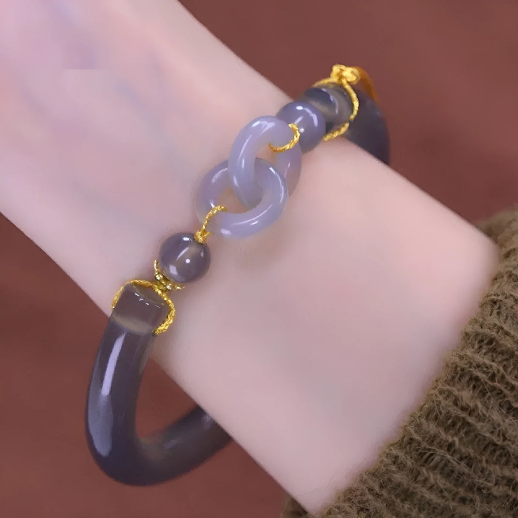 Grey smoke purple agate bead bracelet with metal ring buckle closure on a wrist.