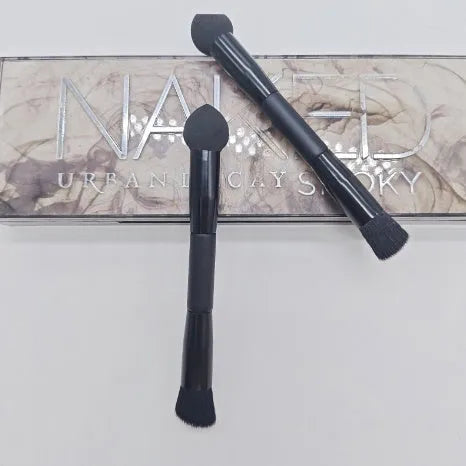 Elegant black double-headed makeup brush with a synthetic fibre brush and a miter sponge on a wooden handle.