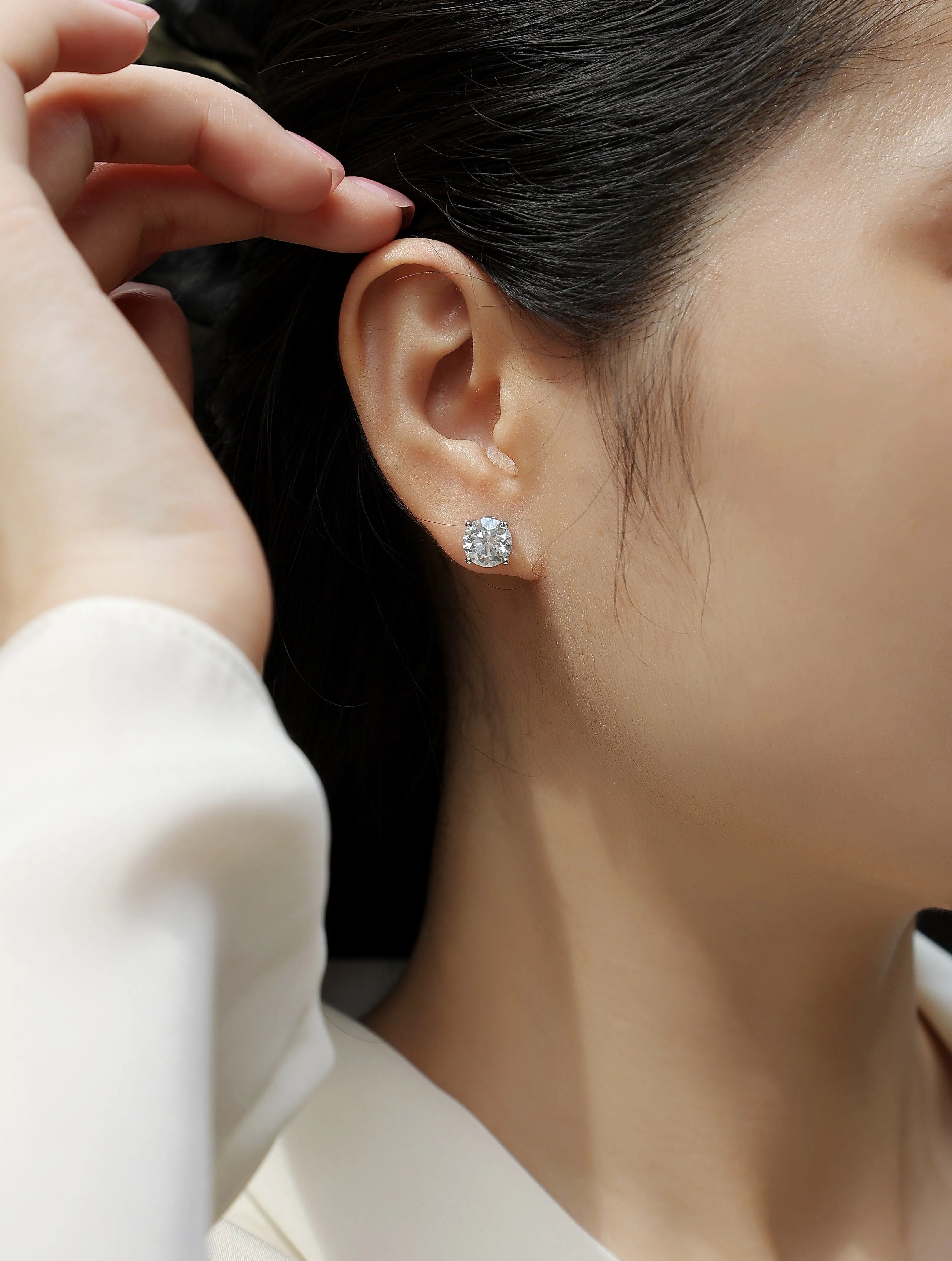 Pair of moissanite stud earrings with platinum-plated S925 silver settings, on a gift box, available in black or transparent stones