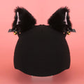A plush fabric helmet cover with cartoon print and 3D ears, next to a matching beanie hat, on a neutral background.
