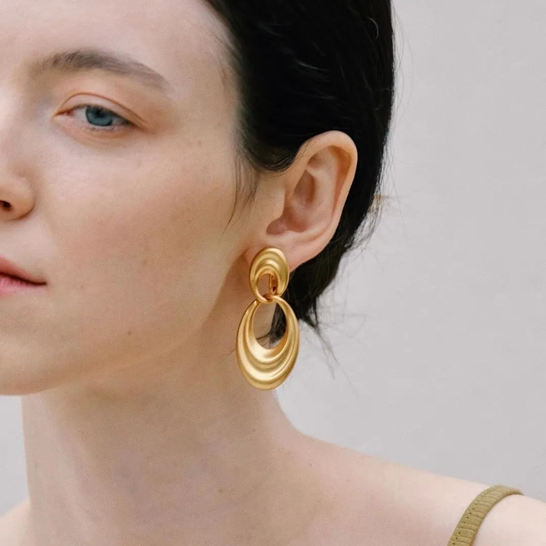 Close-up of French retro double circle copper earrings with a quicksand finish in a U-shape.