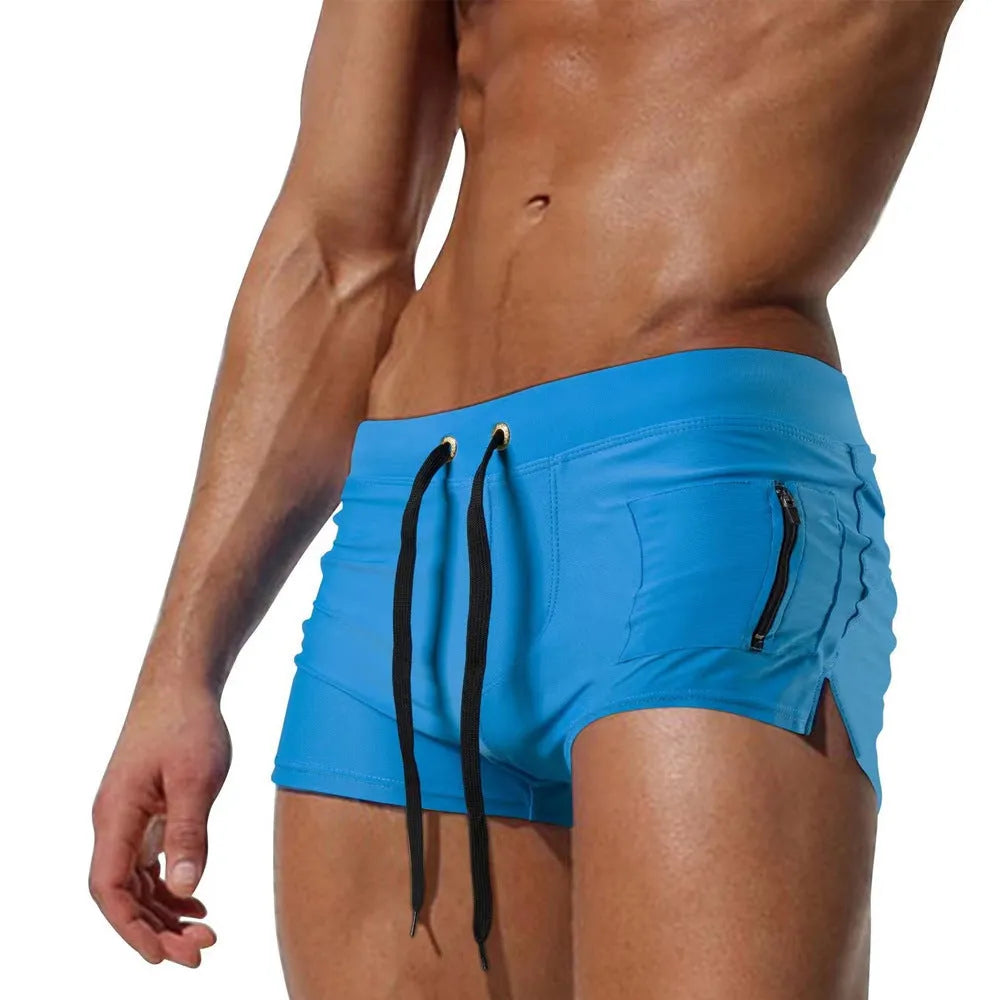 Men's black high waist swimming trunks with a lace-up front closure on a solid colour background.