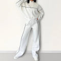 Casual polyester suit set showing a long sleeve mock neck hoodie and striped trousers on a model.