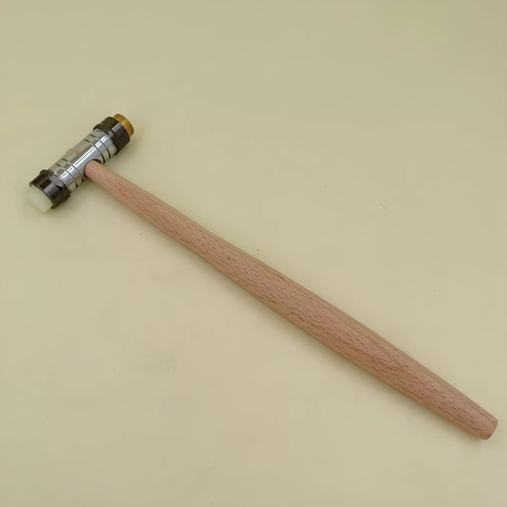 Brass watch repair hammer with wooden handle on a workbench