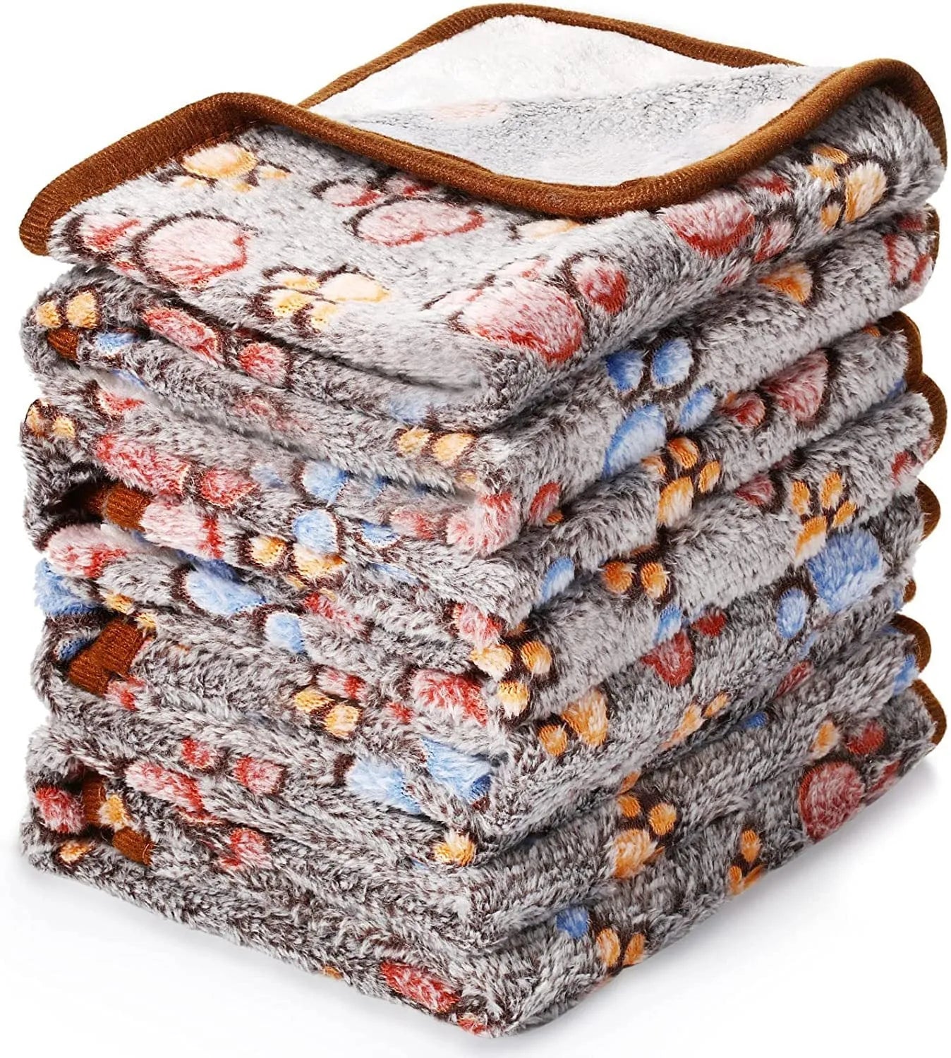 Coral fleece pet blanket with dog's paw print pattern in beige, shown in a large size on a dog bed.