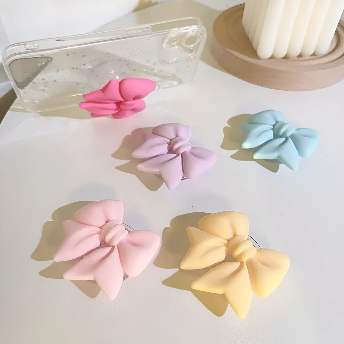 Bow bracket plastic mobile phone stand for lazy binge-watching, available in pink, purple, rose red, yellow, and blue.