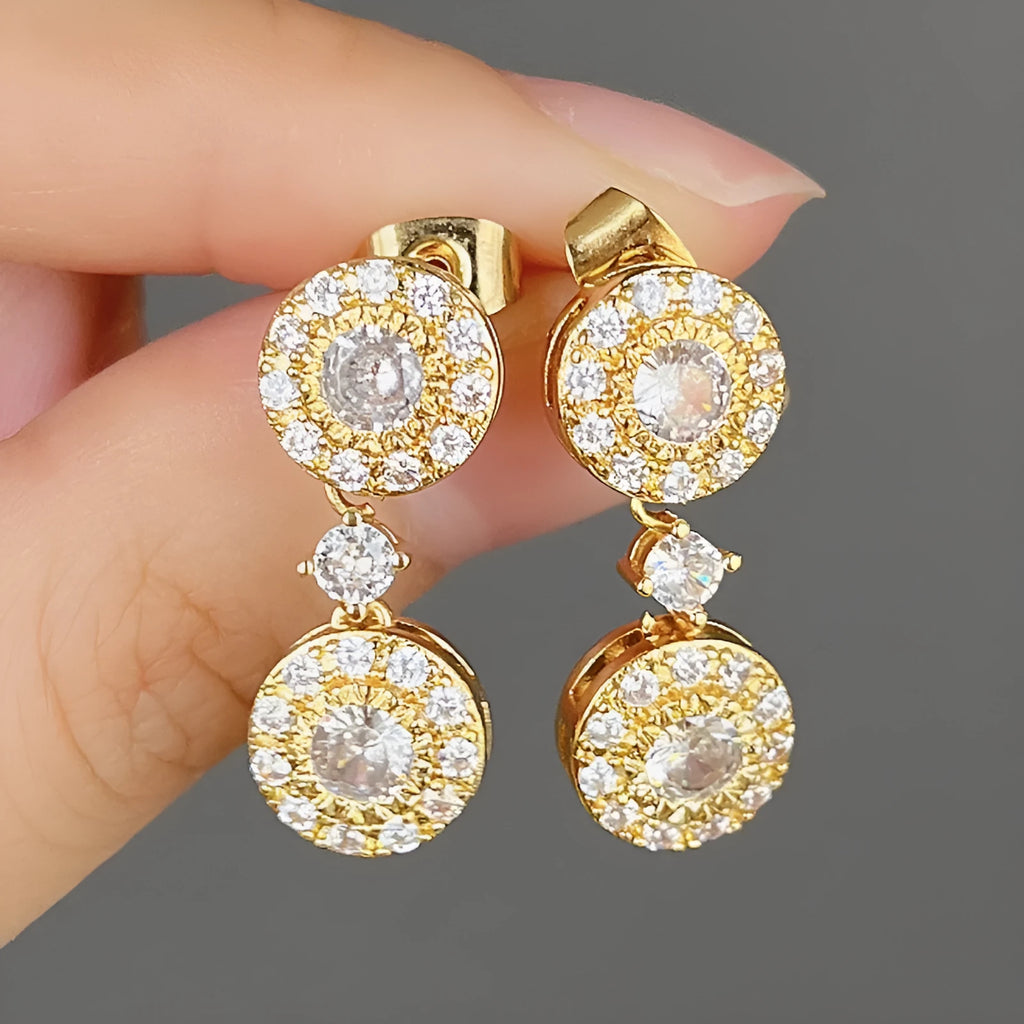 Women's gold copper round zircon stud earrings on a light background