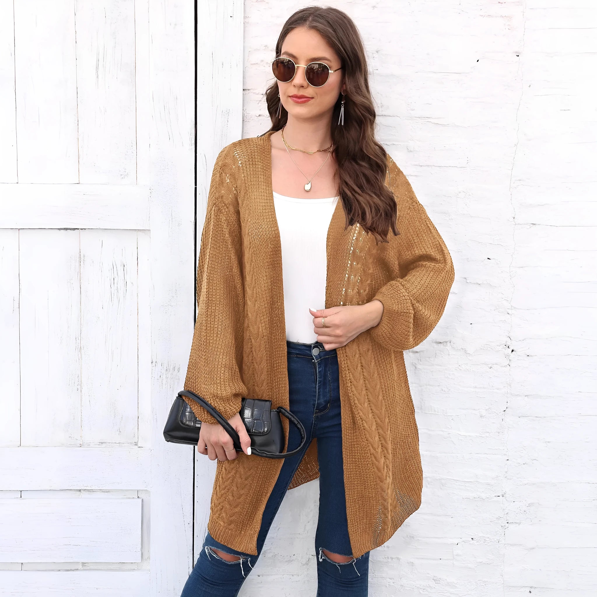 Women's loose fit acrylic sweater coat cardigan in a solid colour on a hanger.