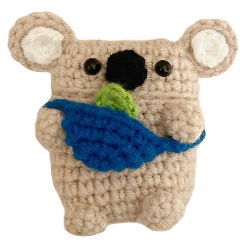 Handmade knitted AirPods case shaped like a backpack with koala ears on a blue background.