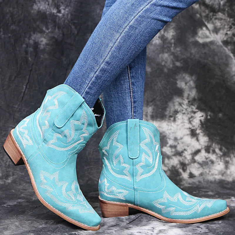 Women's blue embroidered cowboy boots with a wedge heel and pointed toe on a white background.