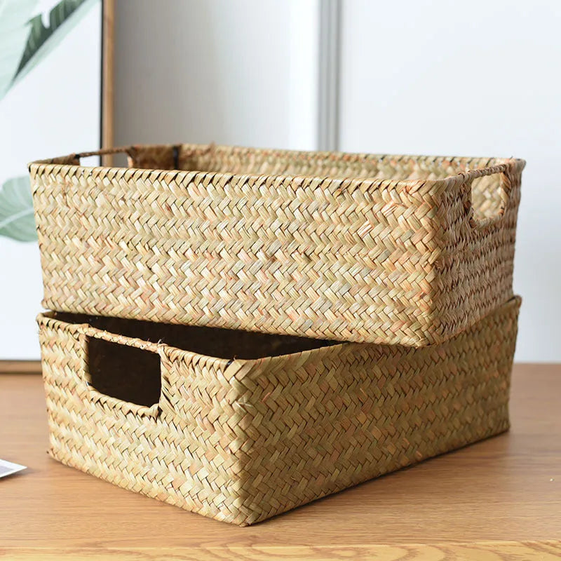 Handwoven grass rectangular storage baskets in various sizes on a wooden shelf