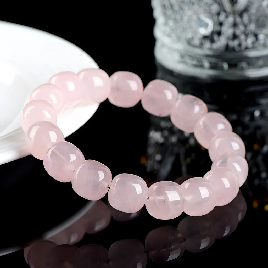 Pink crystal barrel bead bracelet on a black adjustable cord, showing geometric design.