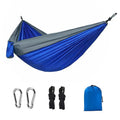 Sapphire blue parachute nylon camping hammock hung between two trees, showing its full 270cm length.