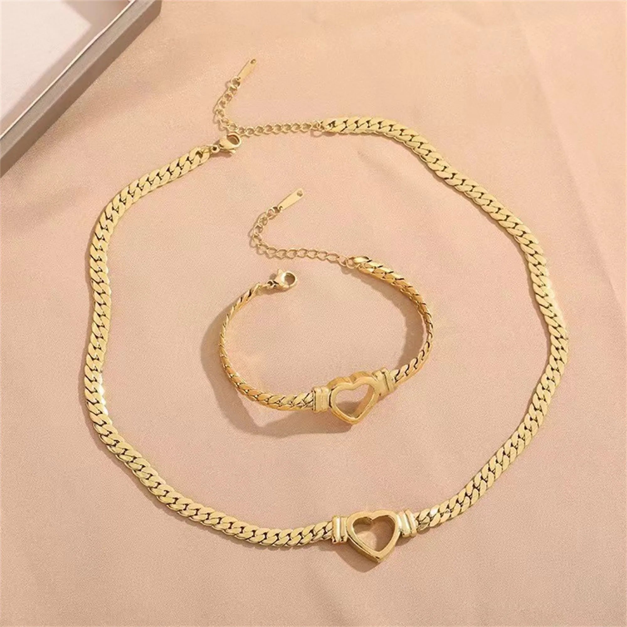 Gold titanium steel personalised love chain necklace and bracelet set with Cuban links and heart shape on white background