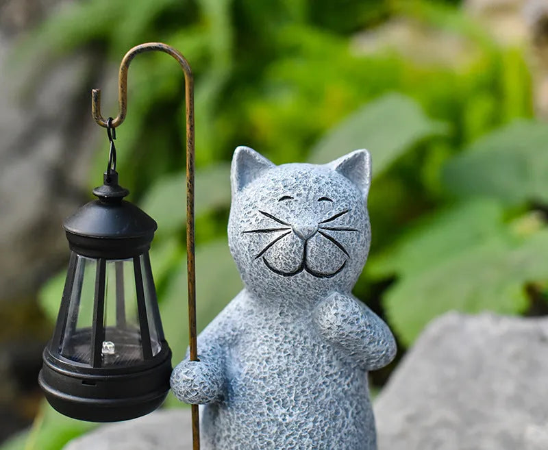 Solar-powered garden light with decorative resin kitten ornament lifting a lamp.