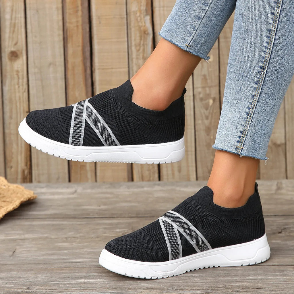 Black women's low-top flyknit mesh flat shoes with round toe and tassel detail on a rubber sole.