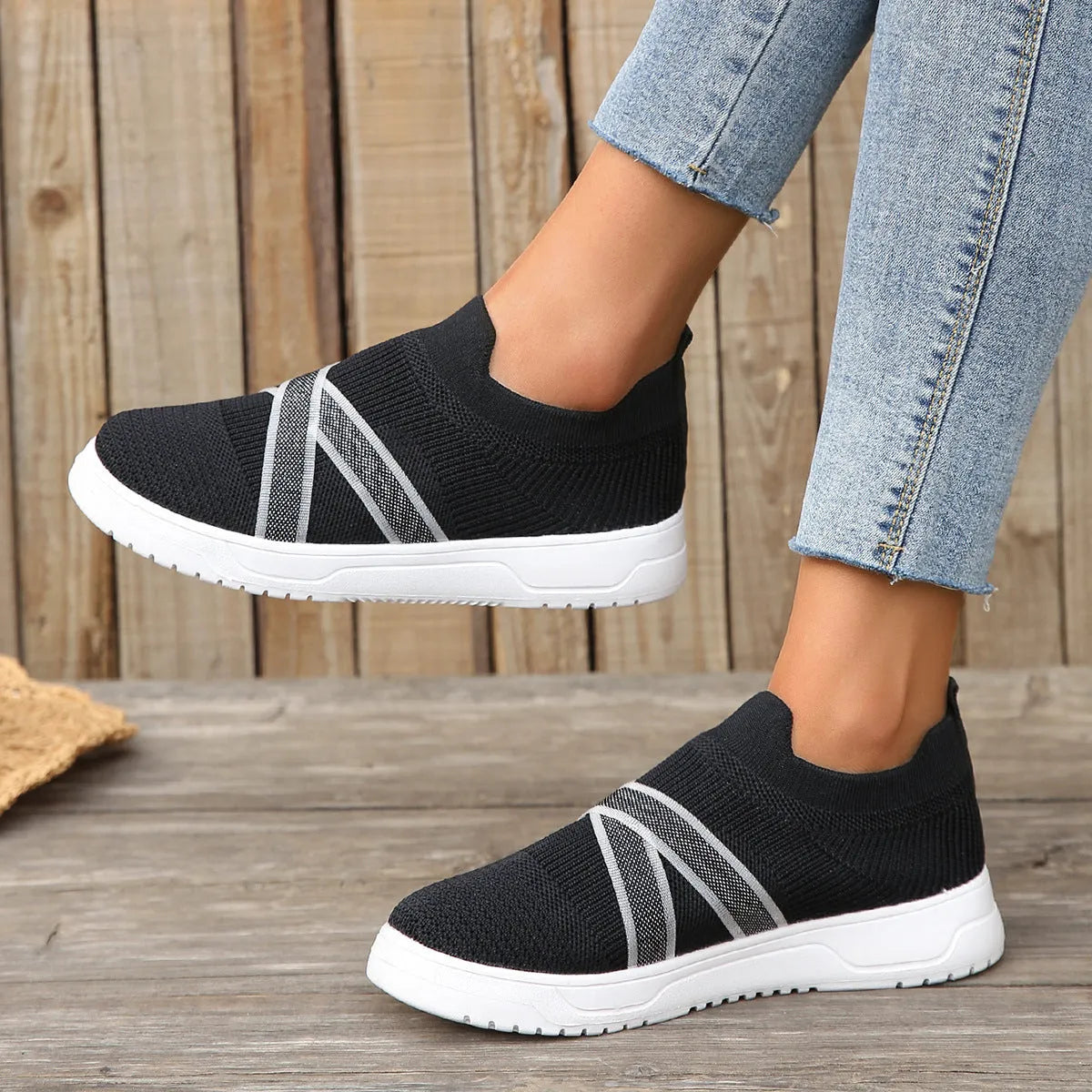 Black women's low-top flyknit mesh flat shoes with round toe and tassel detail on a rubber sole.