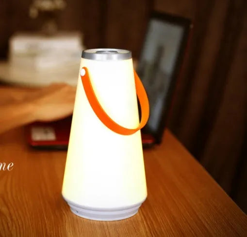 White rechargeable LED bedside lamp with adjustable brightness on wooden table