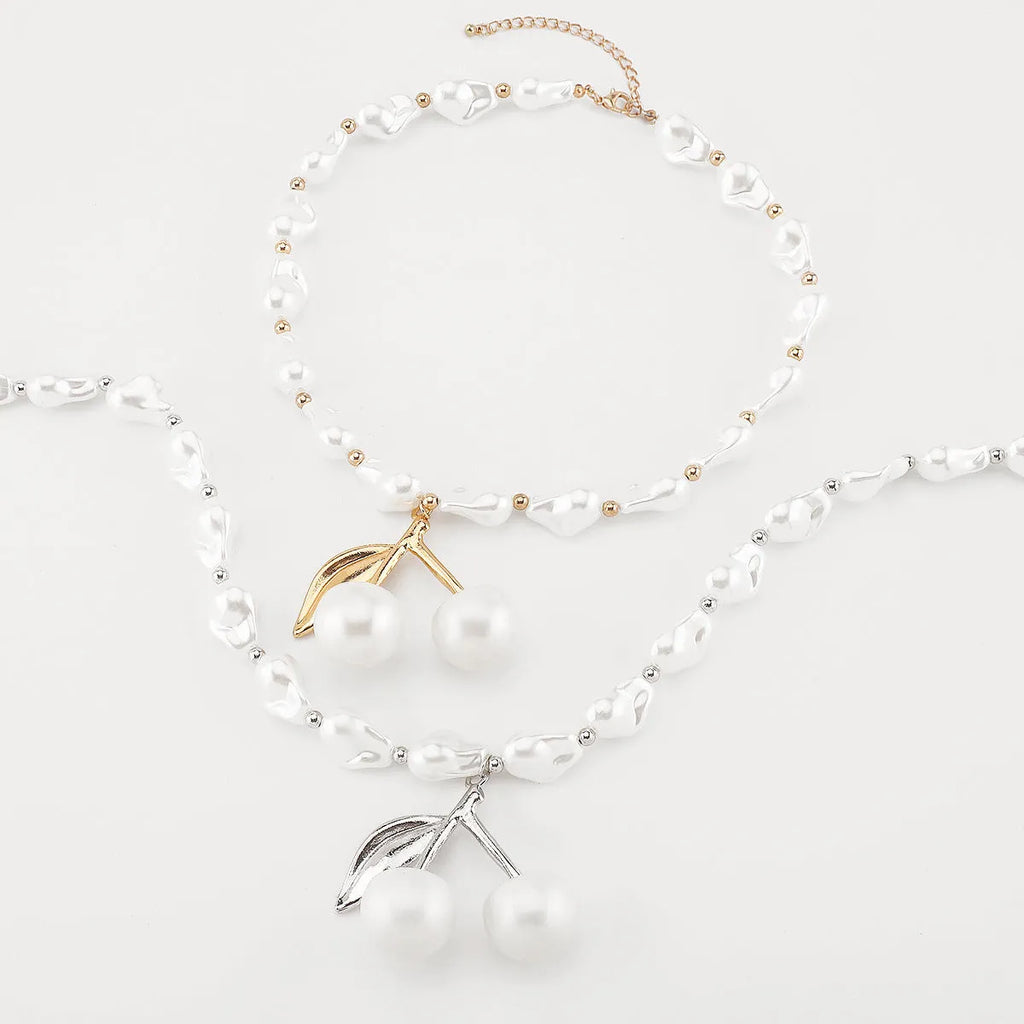 Gold tone irregular cherry and pearl necklace on a model, showing adjustable length up to 60cm.