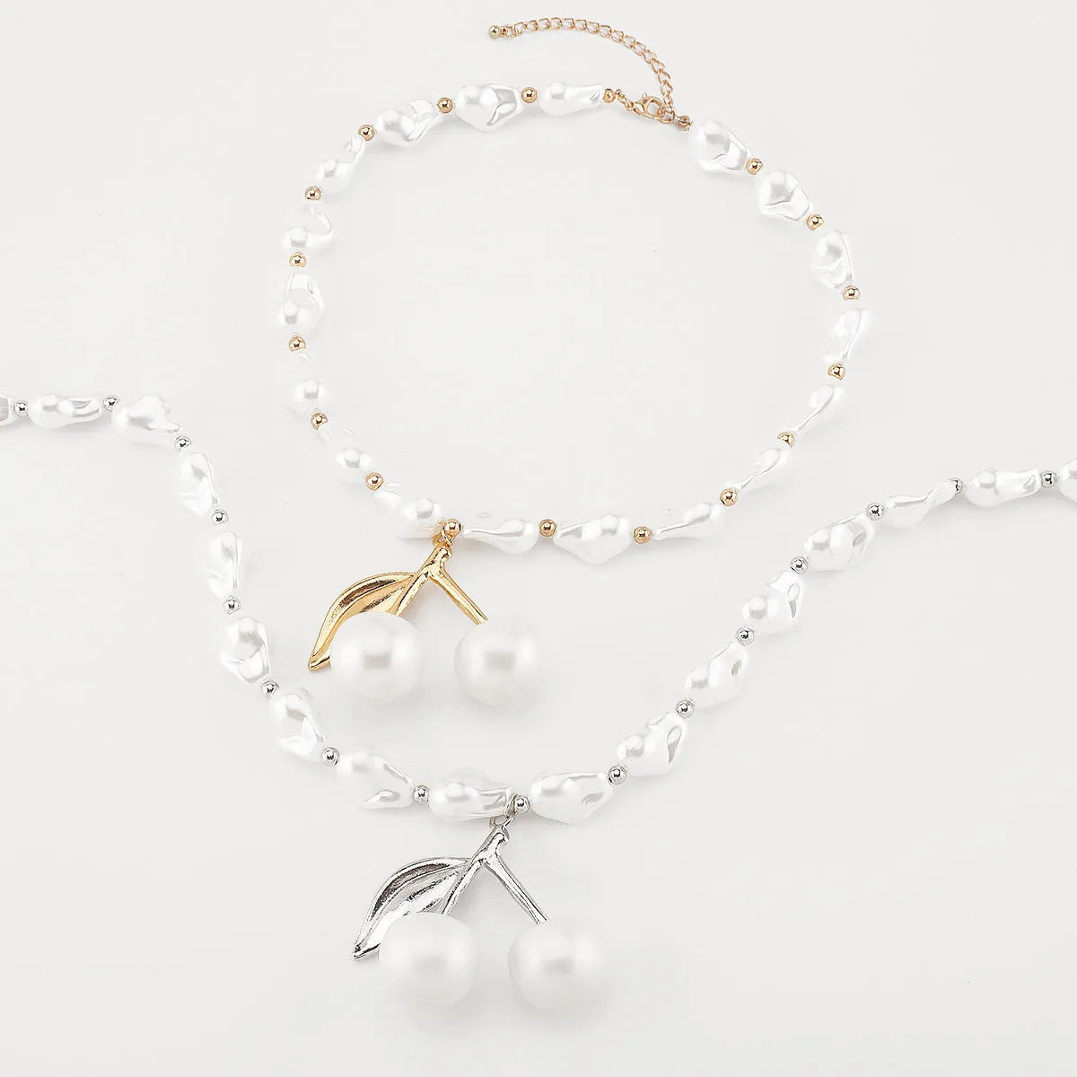Gold tone irregular cherry and pearl necklace on a model, showing adjustable length up to 60cm.