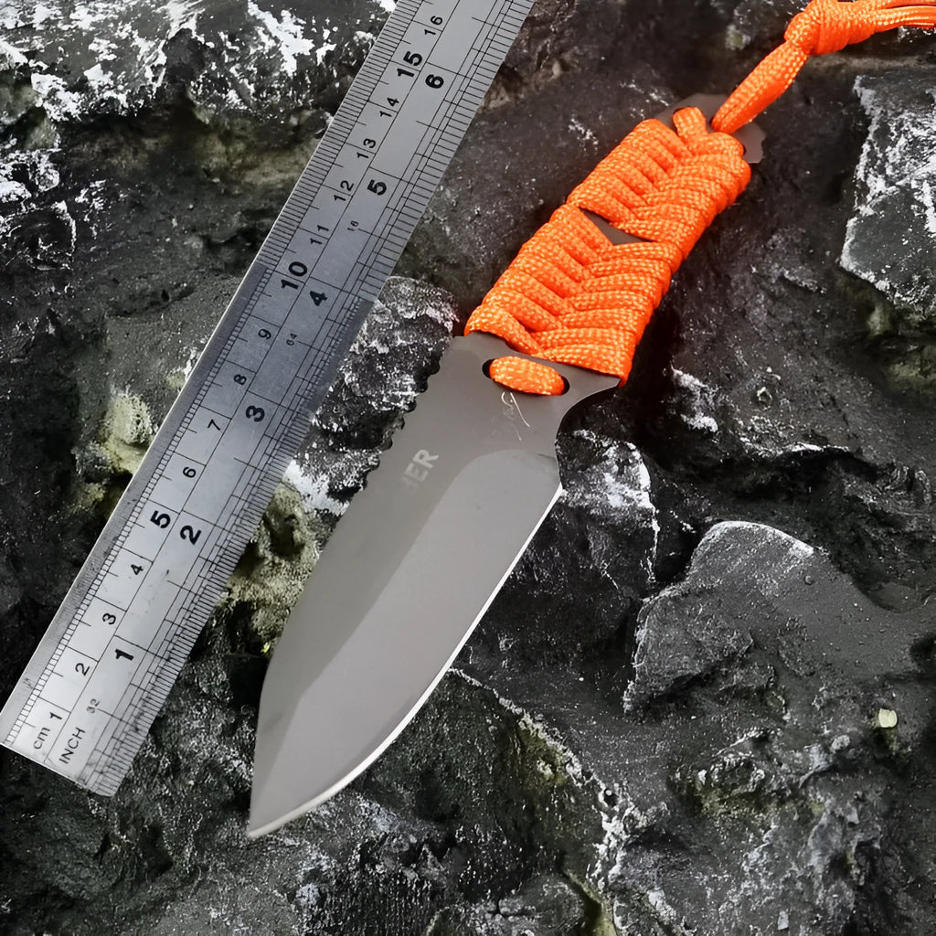 Straight camping survival knife with binding rope handle next to ABS sheath