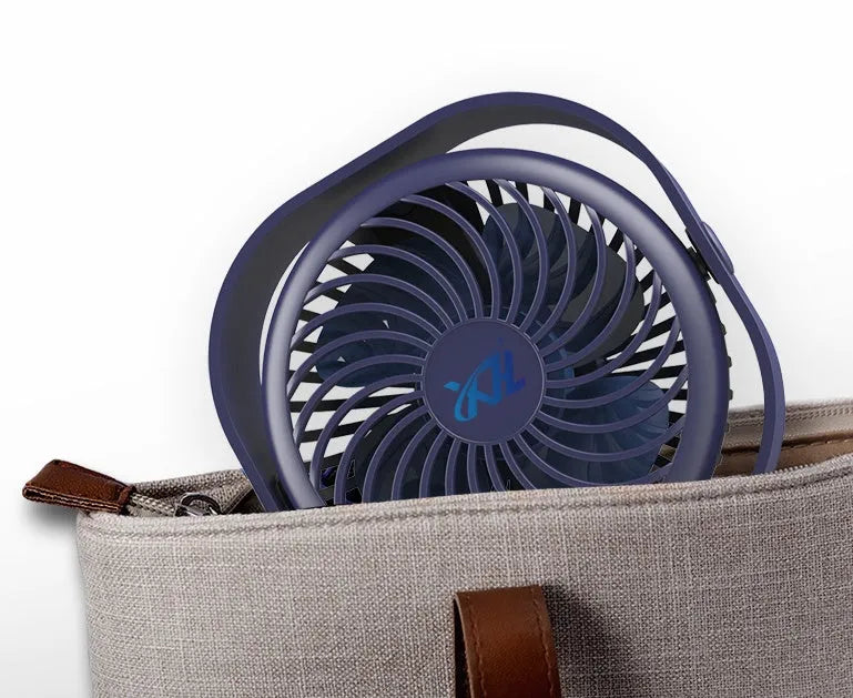 Pink USB rechargeable desk fan with rotating head on a wooden desk.