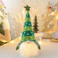 Christmas gnome faceless doll with LED light in red and green, 41 cm tall, on a shelf