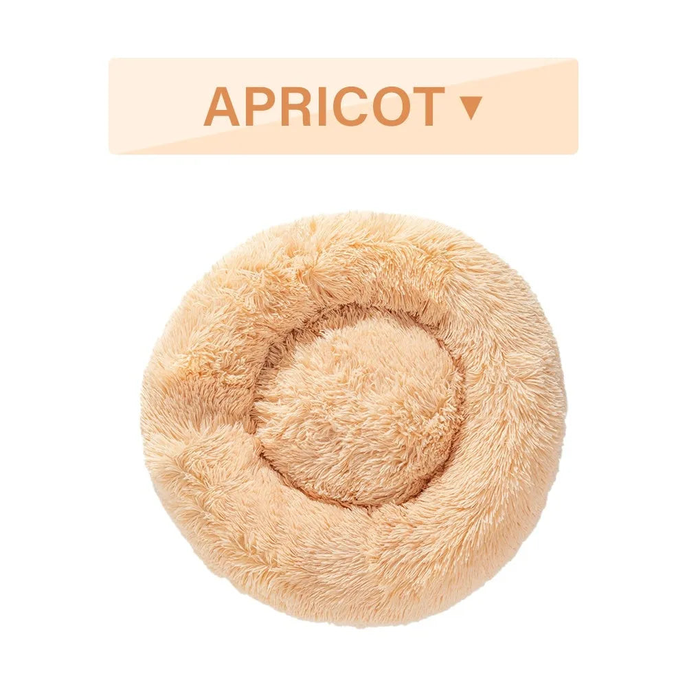 Fluffy donut-shaped pet bed in long plush fabric, shown in a light grey colour with a raised edge.